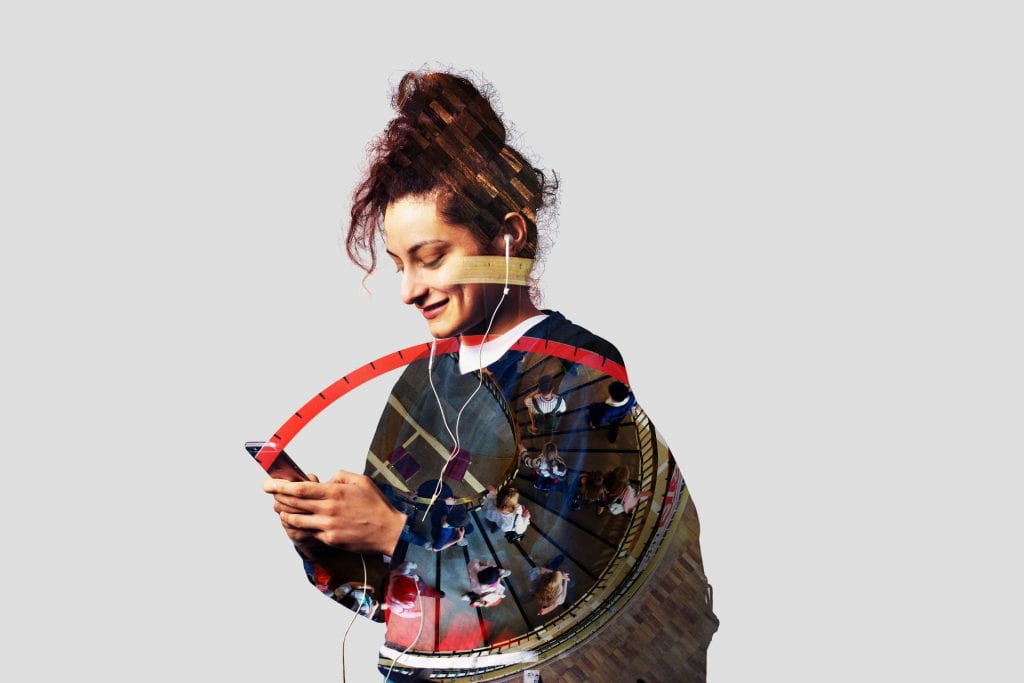 A female student smiling, looking down at her phone