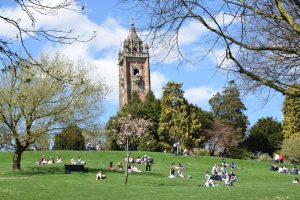 Brandon Hill tower and park in Spring with blue sky and groups sitting on the grass