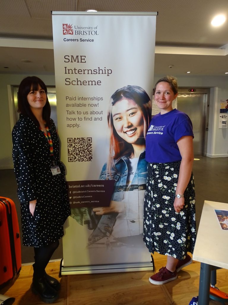 A picture of jenny and Rachel smiling standing by an SME internship scheme banner 