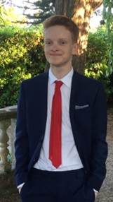 A picture of Harvey, a male student in a suit, smiling