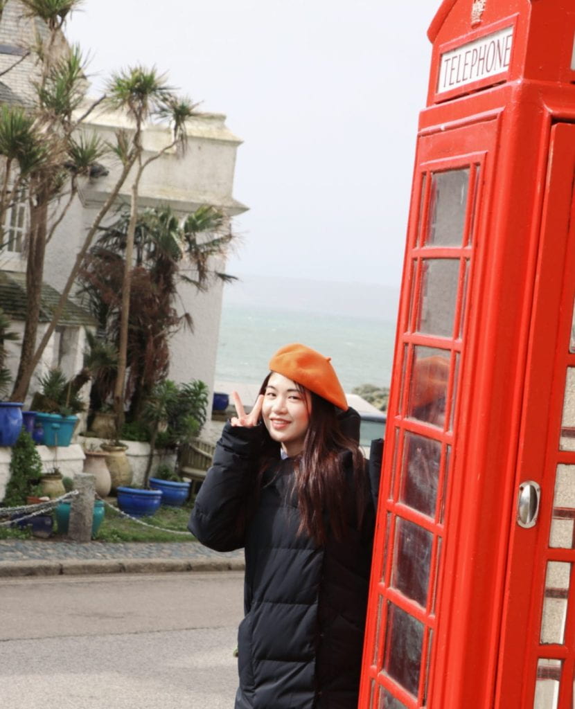 Mengying next to a red phone box