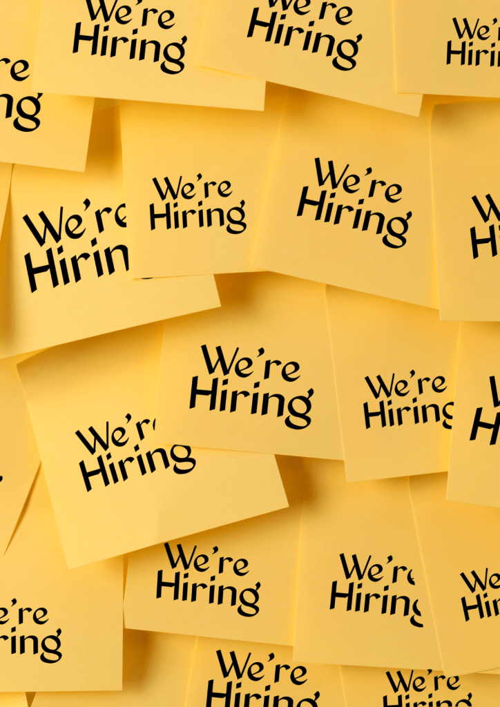 Layered yellow post-it notes that all say "We're hiring"