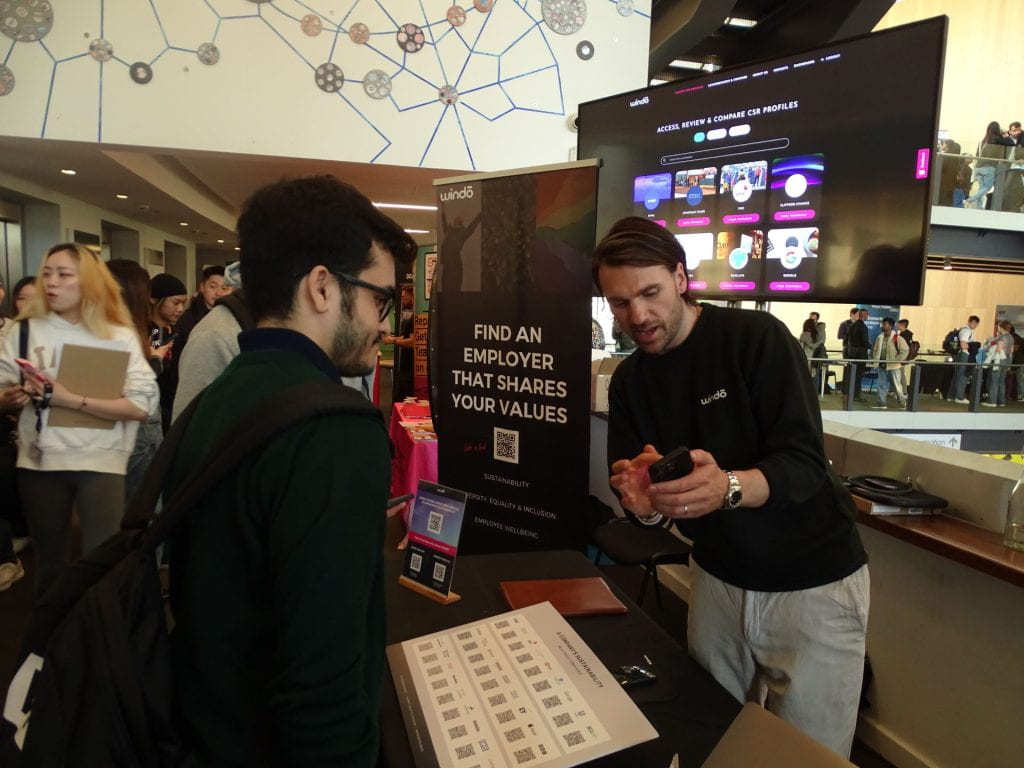 A photo of Oli talking to a student at the Get Hired fair.