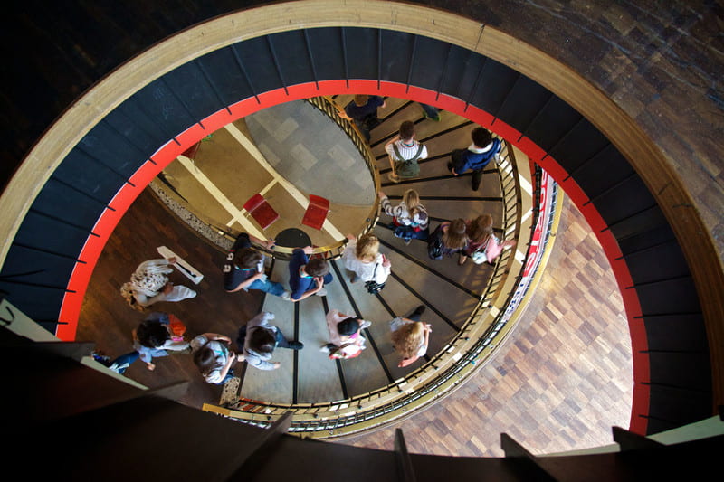 A group of people walking up a spiral staircase